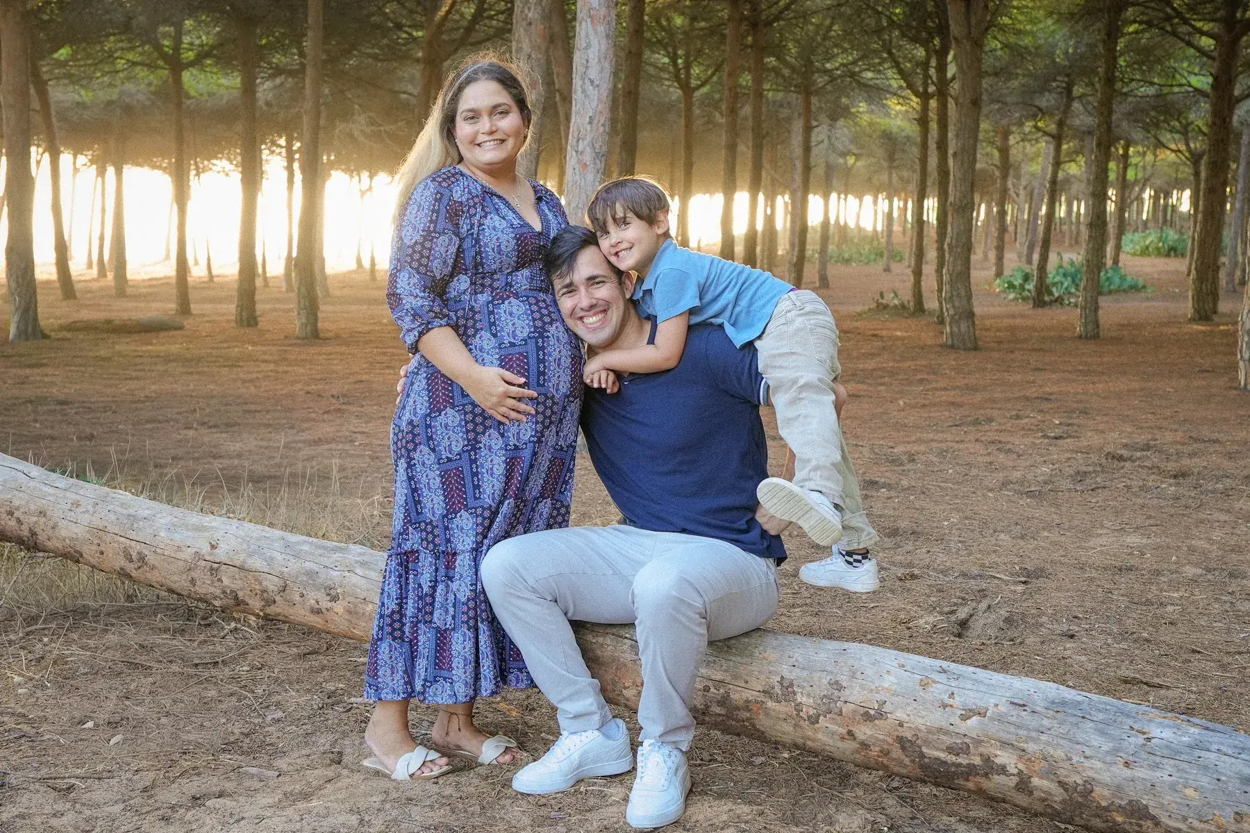 Família sentada num tronco num pinhal do Algarve com luz dourada
