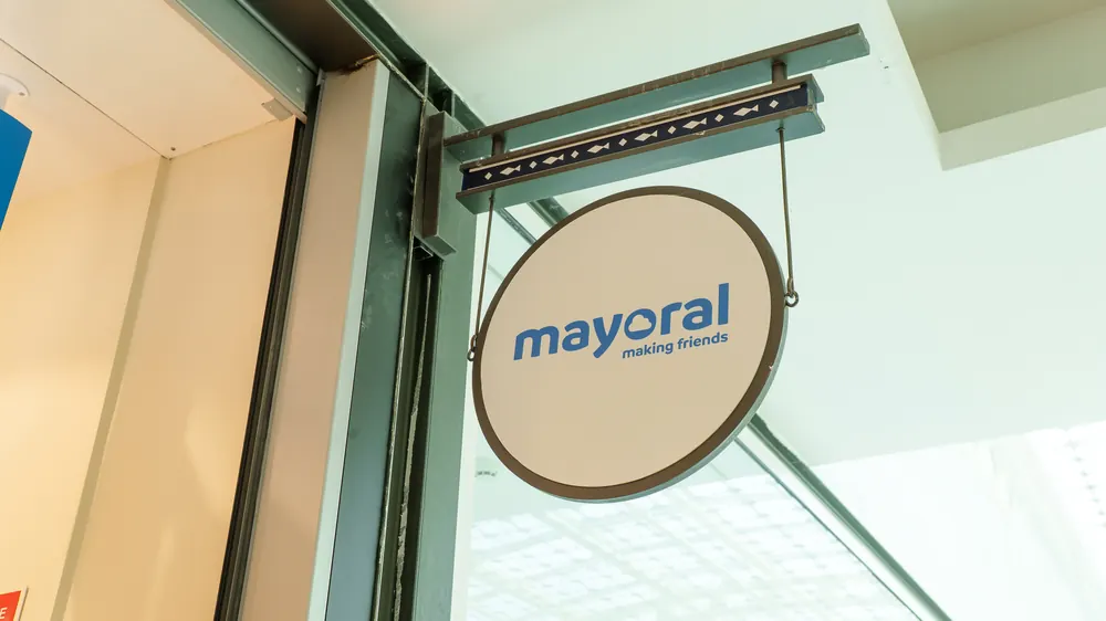 Placa circular suspensa com o logótipo de uma loja num centro comercial